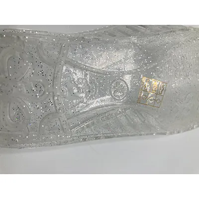 Sandals made of transparent PVC plastic with glitter. Product sold online.