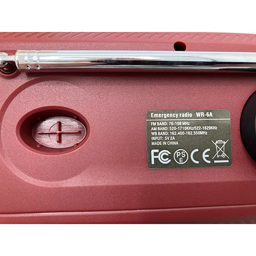 Maroon/burgundy radio with black details. Fitted with a crank, solar panel, antenna, textile strap and a small display window. Includes a black USB/USB-C cable.