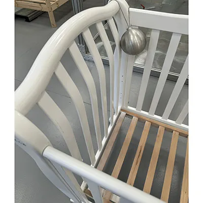 Children's wooden cot in white design, on wheels. Product sold online.