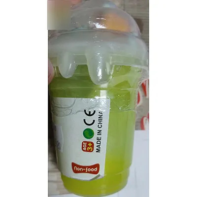 Yellow slime with small coloured balls and three larger coloured rollers in the plastic lid of the toy.