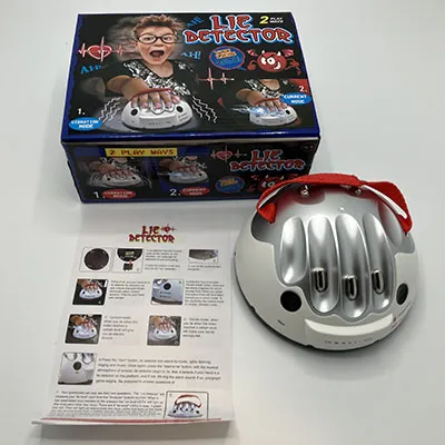 Toy lie detector made up of electronics fitted in a hard plastic half-sphere shell with suction cups. Metallic grey with a red textile strap.