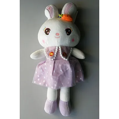 White plush bunny in a purple dress, with an accessory in the shape of a carrot. The toy has a suction cup attached to its head with a string. Size of 40 cm.