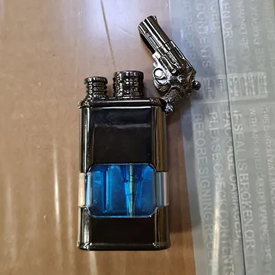 Metal lighter with a built-in clock. On top of the lighter there is small gun attached.