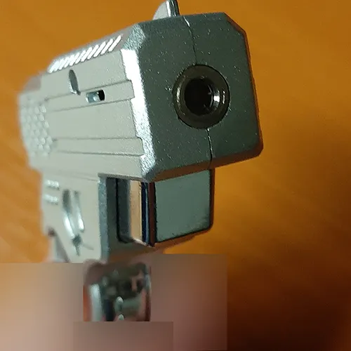 Lighter in the shape of a small pistol. The part that is usually the magazine (the part that the pistol is held by when firing) is in the shape of a circle. The trigger of the pistol is the operating button. When pressed, a flame shoots out of the barrel of the pistol.