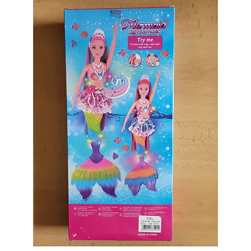Doll with long colourful hair, a lace skirt with plastic beads, a colourful plastic bodice, plastic pearls on her neck and a fish fin. The product also includes a plastic dolphin in pink or blue, a hairbrush, shells, clams and a starfish. Size: 39 cm.