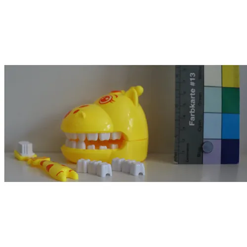 Toothbrush set consisting of one Giraffe head (yellow) with hinged jaw and two ‘tooth crowns’ on which to hang toothbrushes. Product sold online, in particular via Amazon (ASIN: B0DPJCLKBL).