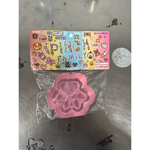 Slime toy shaped like a cat's paw with loose beads/figurine.