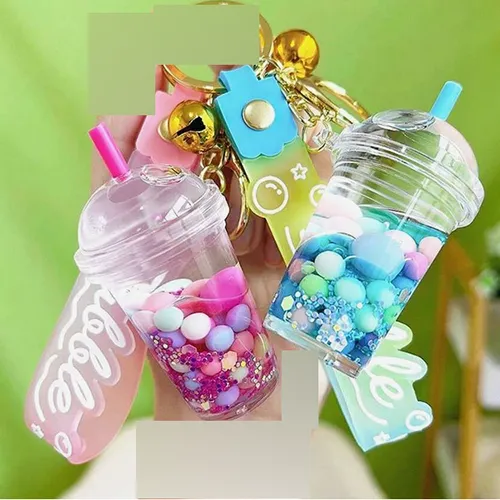 Three keyrings with a bubble tea cup figure. The plastic figure contains two non-mixable liquids (pink and clear) in containers sealed by a rubber plastic stopper. Product sold online, in particular via Shein (product identifier, SKU: sc2407277808880181).