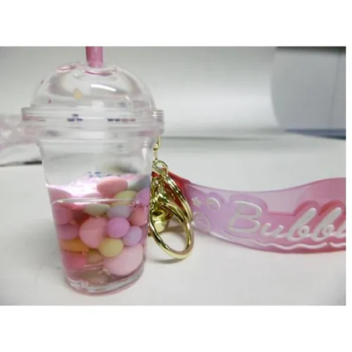 Three keyrings with a bubble tea cup figure. The plastic figure contains two non-mixable liquids (pink and clear) in containers sealed by a rubber plastic stopper. Product sold online, in particular via Shein (product identifier, SKU: sc2407277808880181).