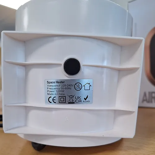 Oval-shaped white fan heater with a black grille and a black power cord attached. Product sold online, in particular via Amazon (ASIN: B0CMCZT6QR).