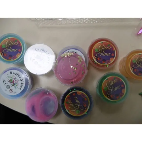 Twelve pots of colourful toy slime with small bags of sprinkle decorations. Product sold online, in particular via Amazon (ASIN: B0D6Z7HC9M).