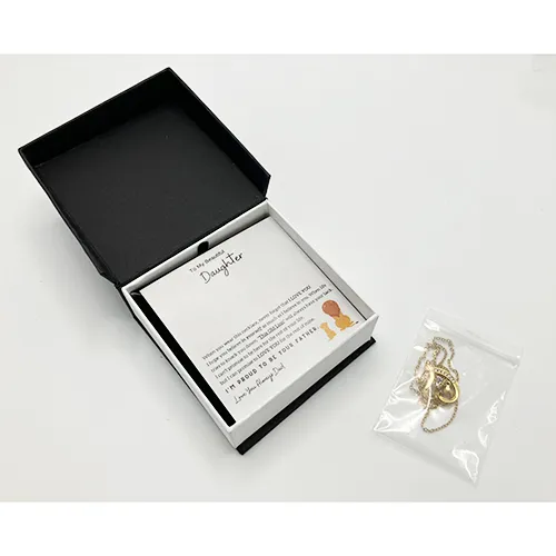Gold-coloured necklace with a heart-shaped charm studded with rhinestones.