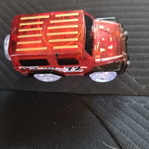 Battery-operated plastic toy in the shape of a car provided with a plastic track, light and AA batteries.