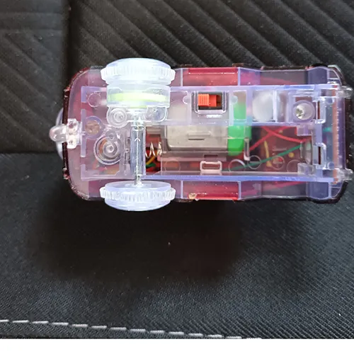 Battery-operated plastic toy in the shape of a car provided with a plastic track, light and AA batteries.