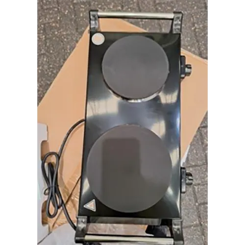 Electric cooking plate with a wall plug.