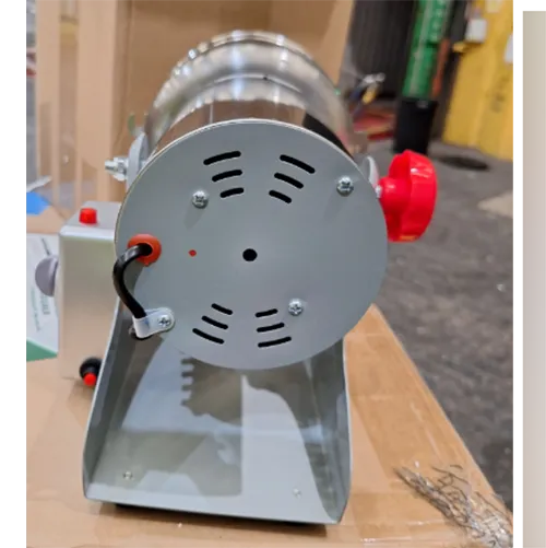 Small metal countertop crushing tool with a wall plug, spare blades and measuring spoons.