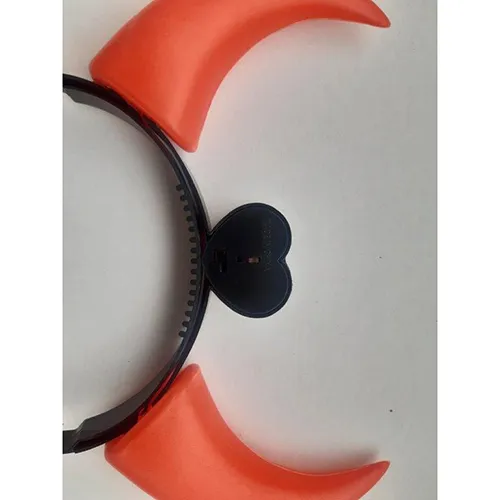 Glowing toy plastic headband in the shape of devil horns, battery-operated. In the middle of the headband there is a heart-shaped cover for two AG13 batteries.