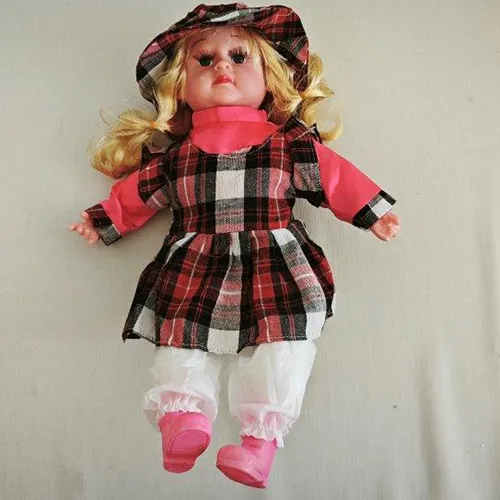 Textile doll with a plastic head, hands and shoes. The doll has long blonde hair and is dressed in a coloured dress and underpants. Under the dress, there is a removable battery compartment for three pieces of LR44 batteries.