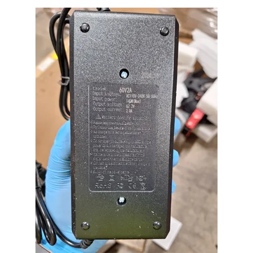 Electric scooter with charger and non-UK plug (2-pin). Other product identifiers “Racing Products” on red bracket