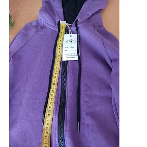 Children's jumpsuit, made of purple knitwear, with a hood, two patch pockets on the front and a drawstring with loose ends, approximately 31 cm long.