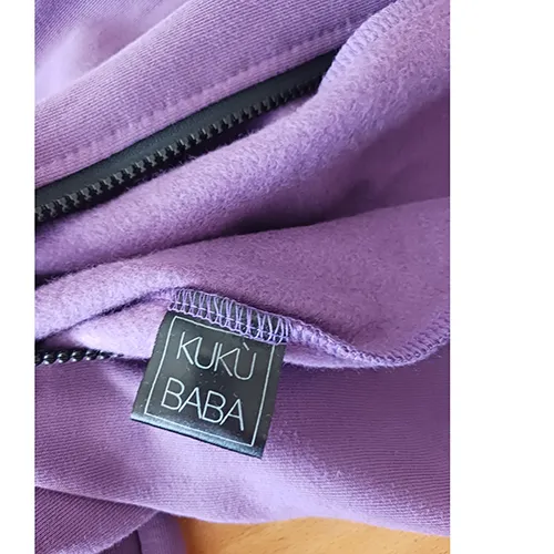 Children's jumpsuit, made of purple knitwear, with a hood, two patch pockets on the front and a drawstring with loose ends, approximately 31 cm long.