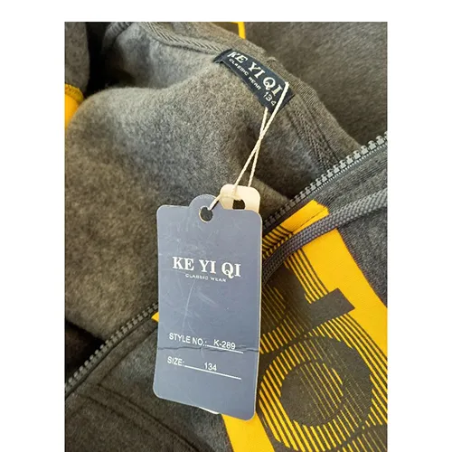 Clothing set intended for young children, made of grey textile knit material. It includes a sweatshirt with hood, zipper and inset pockets. The hood has a drawstring functional textile cord with free ends, about 28 cm long. It includes also a pair of trousers made of light blue textile knit material and with inset pockets.