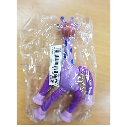 Plastic toy in the shape of a giraffe in purple. The giraffe's legs can be extended, and there are suction cups at the ends of the legs that can be attached to a window, furniture, etc. Product sold online, in particular via Shein (unique identifier: sl2501076151622677)