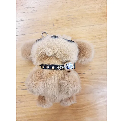 Plush toy, in the shape of a brown puppy with black glasses and a collar with a bell. Product sold online, in particular via Shein.
