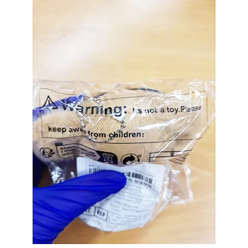 Plush toy, in the shape of a brown puppy with black glasses and a collar with a bell. Product sold online, in particular via Shein.