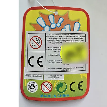 Toy rattle with a green handle and a coloured ball-shaped upper part.