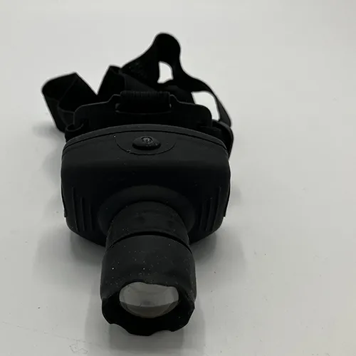 Black hard plastic headlamp with a textile strap. Product sold online, in particular via Garderoben.se.