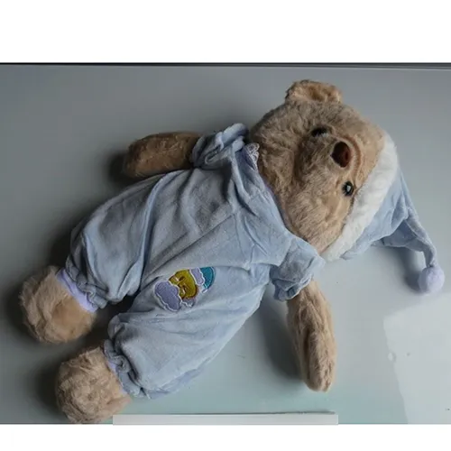 Soft toy in the shape of a bear with black plastic eyes, dressed in blue pyjamas and a matching nightcap. Product sold online, in particular via TikTok.