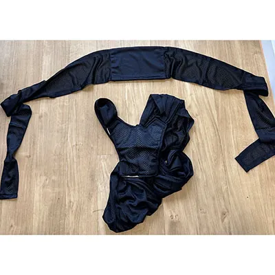 Two-part baby sling without integrated leg openings, black on the outside, with a cloth-like mesh fabric and white padded inserts in some parts. Product sold online, in particular via AliExpress (Unique identifiers: 005007565256736-12000041320277361).