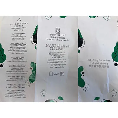 Two-part baby sling without integrated leg openings, black on the outside, with a cloth-like mesh fabric and white padded inserts in some parts. Product sold online, in particular via AliExpress (Unique identifiers: 005007565256736-12000041320277361).