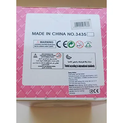 Plastic doll with painted eyes and red lips, wearing a dress.