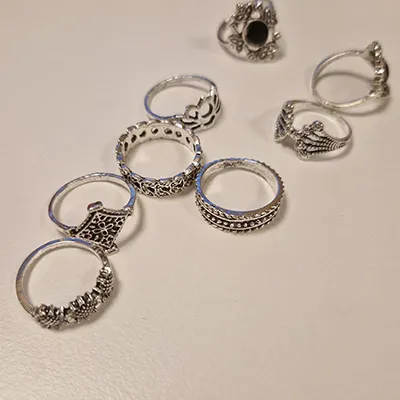 Set of 15 silver - coloured rings with different decorations. Product sold online, in particular via AliExpress.