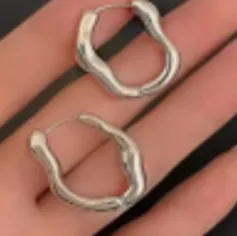 Silver-coloured earrings. Product sold online, in particular via AliExpress.