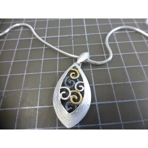 Silver-coloured metal necklace with silver, black and gold-coloured metal pendants, a closure and a chain extender.