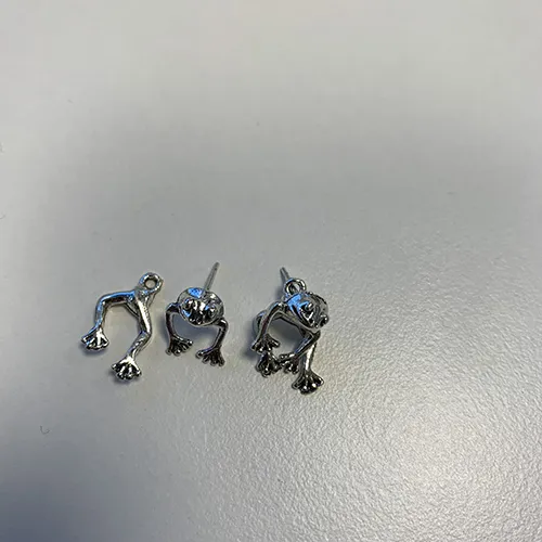 Earrings in a silver colour in the shape of a frog. Product sold online, in particular via Shein.