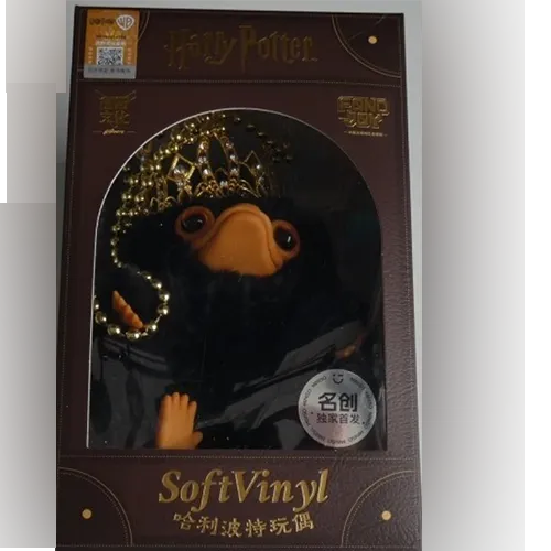 Soft toy, in the shape of a Niffler creature, with a gold-finish crown and a beaded necklace. Product sold online, in particular via Shein.