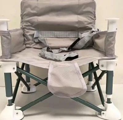Folding camping chair , intended for children, with metal frame and detachable harness.