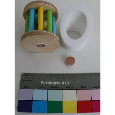 Wooden toy set consisting of one cylinder with its sides made of bars, containing balls; one wooden section with a support for the cylinder on one side and a rotating cylinder with a mirror on the other side Product sold online in particular via montessoritoddlers.com.