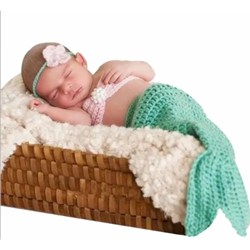 Crochet mermaid costume comprising a pink string bra, a pink flower headband and a blue mermaid’s tail.