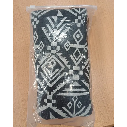 Baby carrier made from white fabric with black patterns and a plastic fastener.