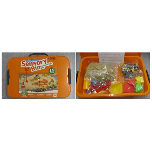 Sensory box with sand including several construction site toy pieces