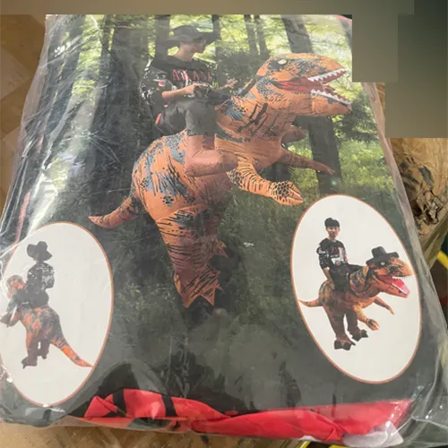 Inflatable fancy-dress dinosaur costume, including a blower, a USB cable and a battery compartment.