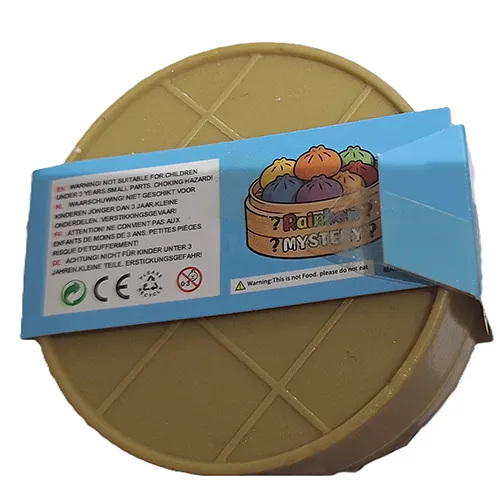 Squeeze toy in the shape of a Chinese dumpling in a plastic container made to resemble a bamboo steamer.