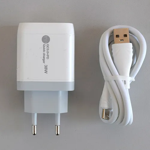 White USB charger with one USB-A and one USB-C port, supplied with a separate USB connection cable. Input: 100-240V, 50-60Hz, 0.35A. Output: 5V/3A, 9V/2A, 12V/1.5A.