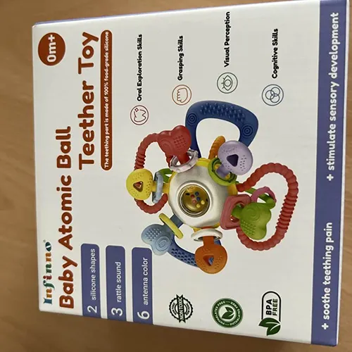 Teething and rattle toy, consisting of a ball containing smaller balls and various soft chewable plastic attachments.