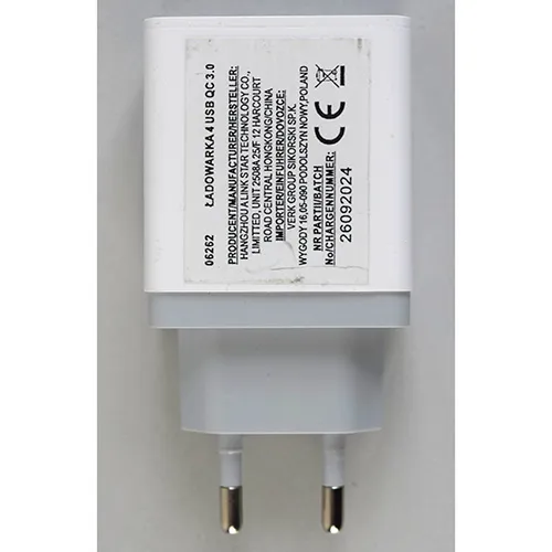 White and grey plastic USB charger with an integrated European plug, featuring four USB Type-A output ports on the face interface, with one port highlighted for quick charging.